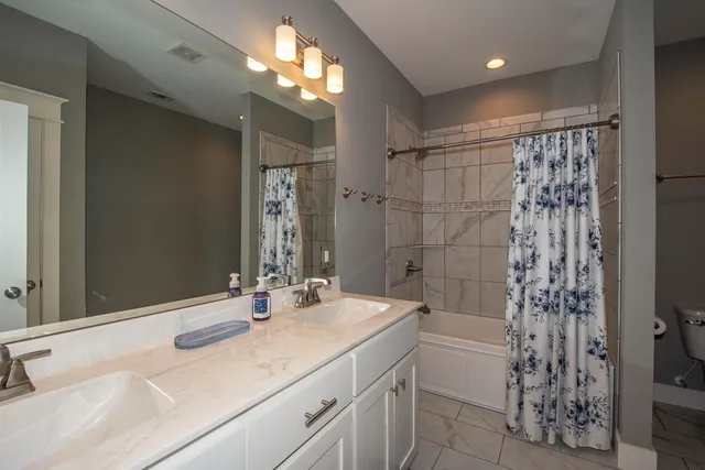 a bathroom with a double vanity sink and a mirror