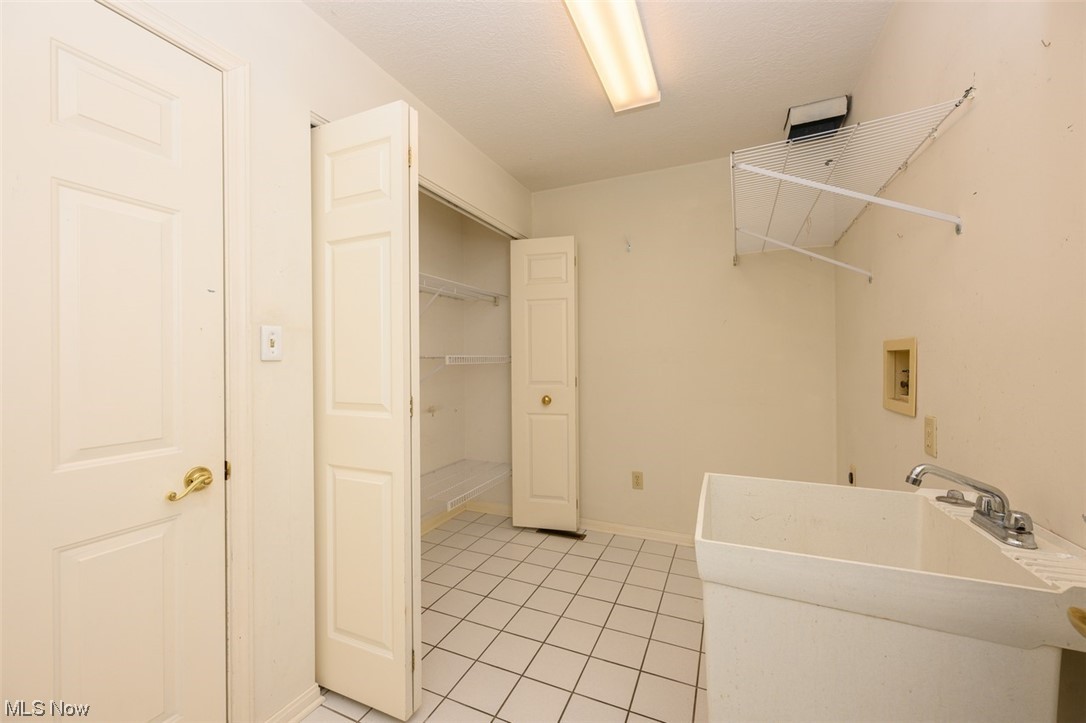 2231 Abbey Road Akron, OH 44312 - Photo 14 of 24 First floor laundry room with storage area and tiled floors
