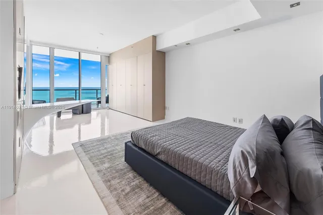 a spacious bedroom with a bed and glass door