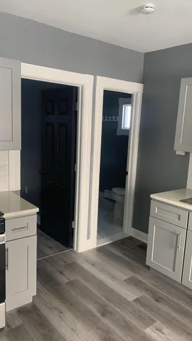 a view of a hallway with wooden floor and closet