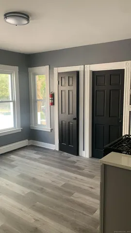a view of an empty room with window and closet area
