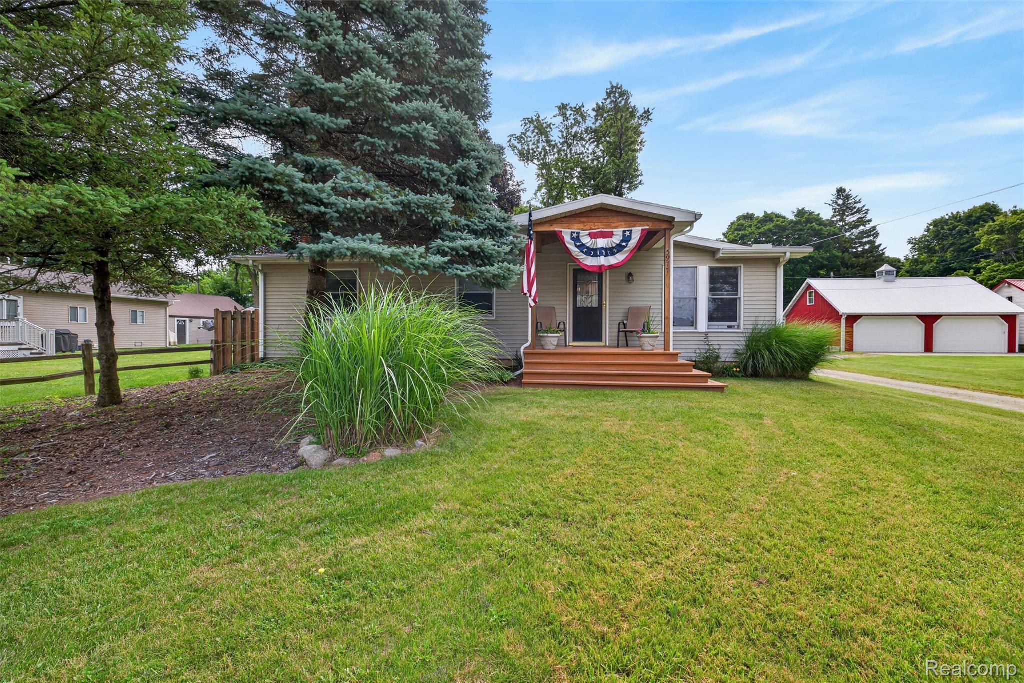 5977 Anglers Road Ortonville, MI 48462 - Photo 1 of 63 Single-story residence featuring light-colored siding, a covered front porch with wood-finish steps, and a grass lawn