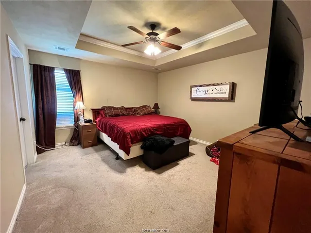 a bed room with a bed and a ceiling fan