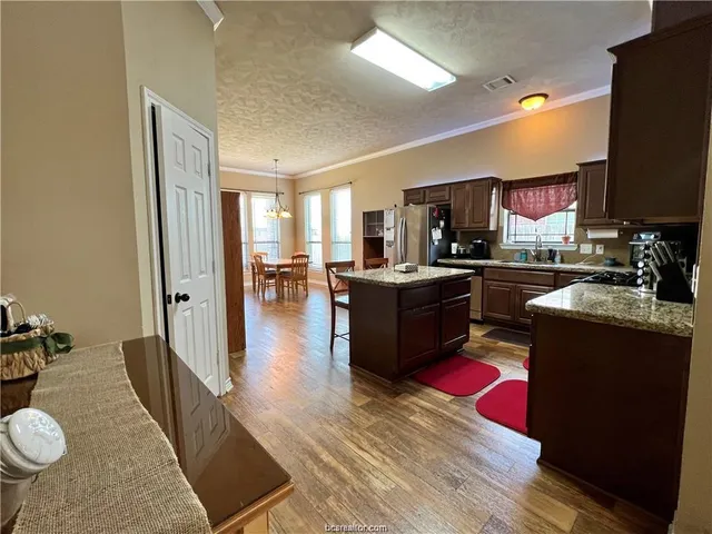 a kitchen with stainless steel appliances granite countertop a stove refrigerator and a sink