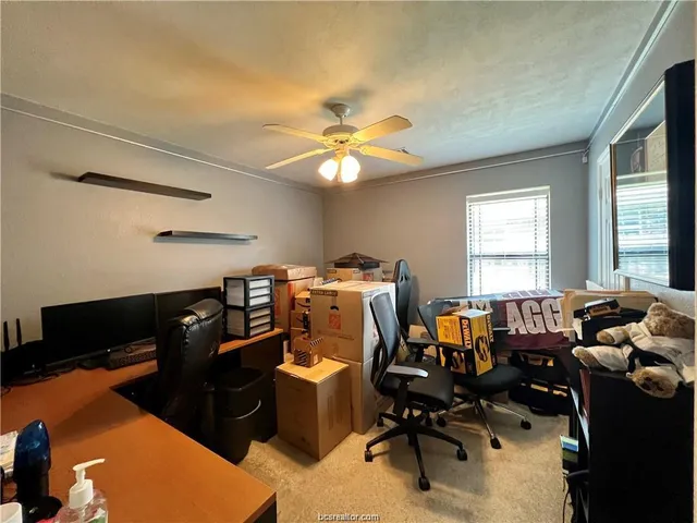 a view of a livingroom with workspace and a window