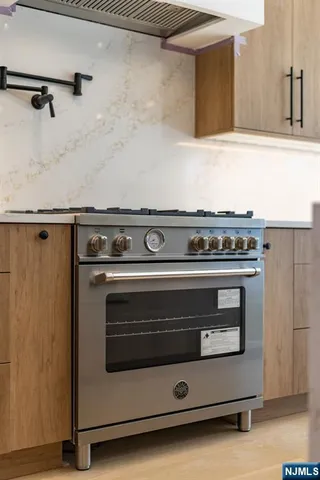 a stove top oven sitting inside of a kitchen