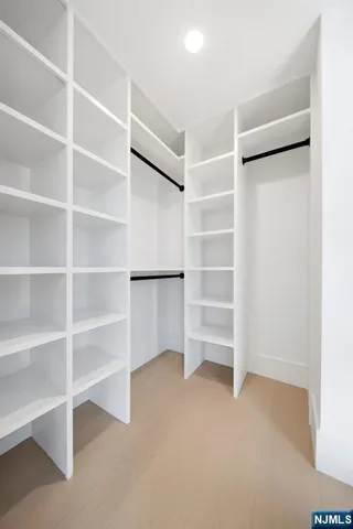 a view of walk in closet with empty racks