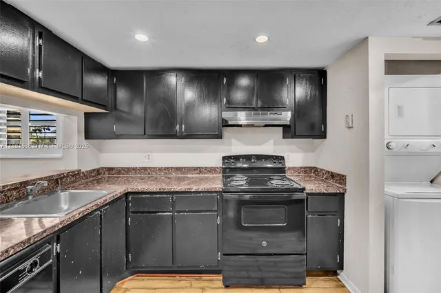 a kitchen with stainless steel appliances granite countertop a refrigerator and a sink