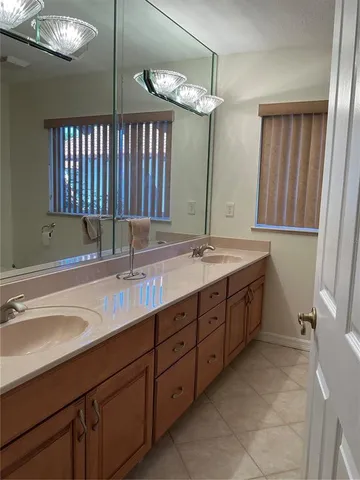 a bathroom with a double vanity sink a mirror and a bathtub
