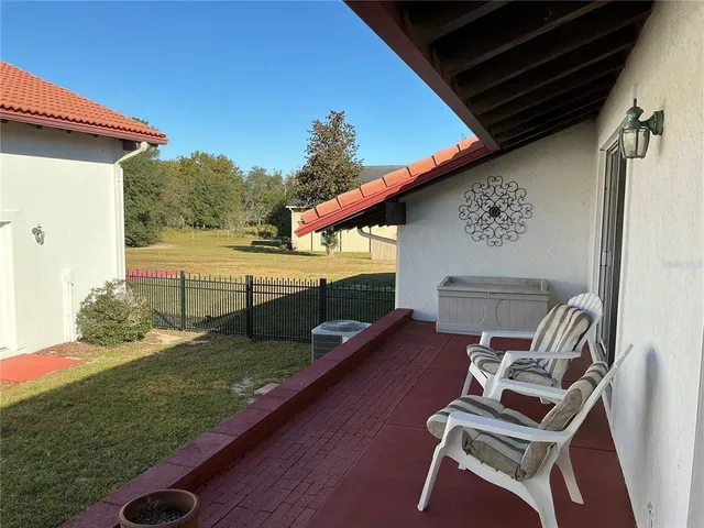 a view of a patio with table and chairs with wooden floor and fence