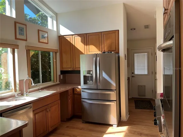 a kitchen with stainless steel appliances granite countertop a refrigerator and a sink
