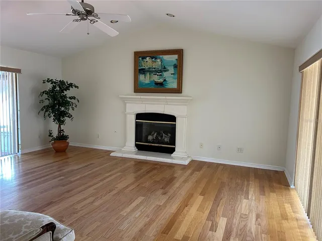 wooden floor fireplace and windows in an empty room