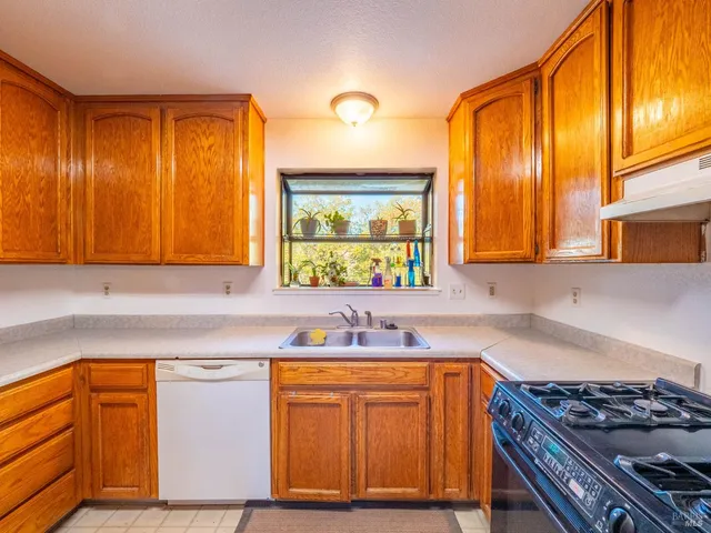 a kitchen with stainless steel appliances granite countertop wooden cabinets sink and stove top oven