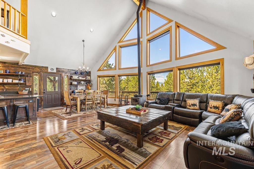30 Redtail Lane McCall, ID 83638 - Photo 15 of 50 Living room featuring light wood-type flooring, a chandelier, healthy amount of natural light, and a high ceiling
