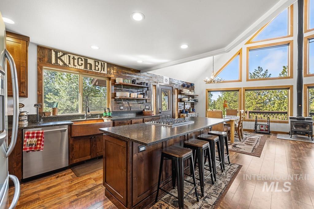 30 Redtail Lane McCall, ID 83638 - Photo 17 of 50 Kitchen with a breakfast bar area, a wood stove, stainless steel appliances, dark wood-type flooring, and a kitchen island
