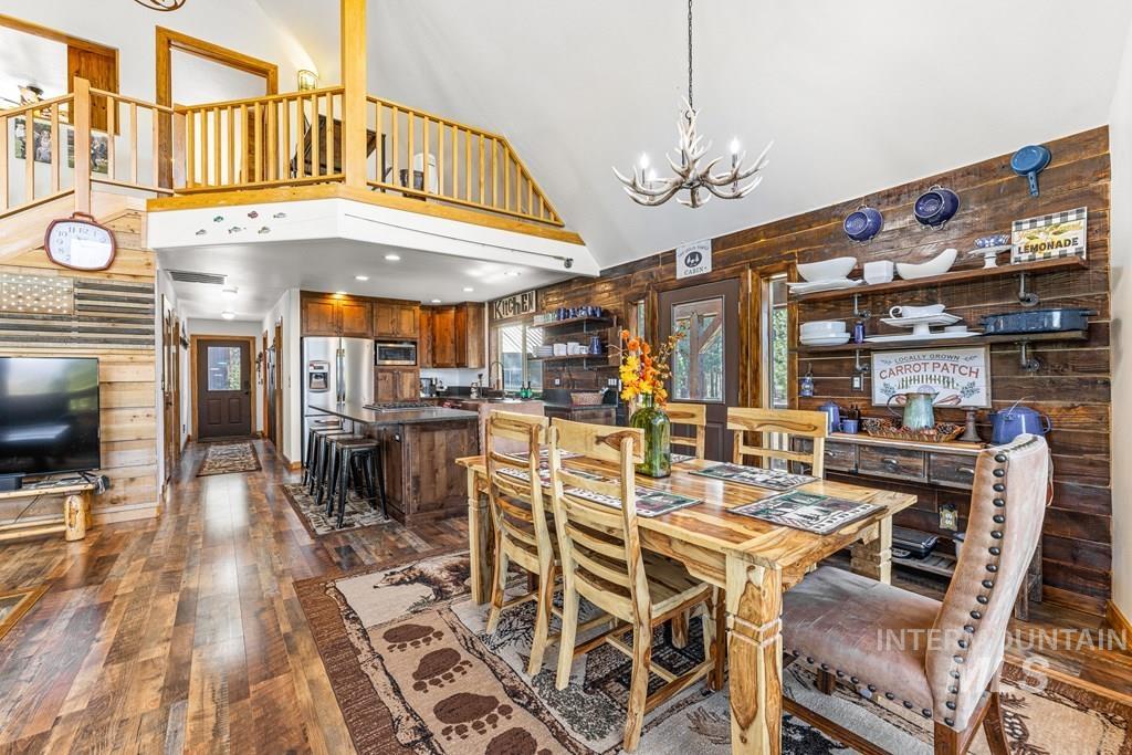 30 Redtail Lane McCall, ID 83638 - Photo 21 of 50 Dining area featuring wood walls, hanging lights, dark wood-style flooring, and vaulted ceiling