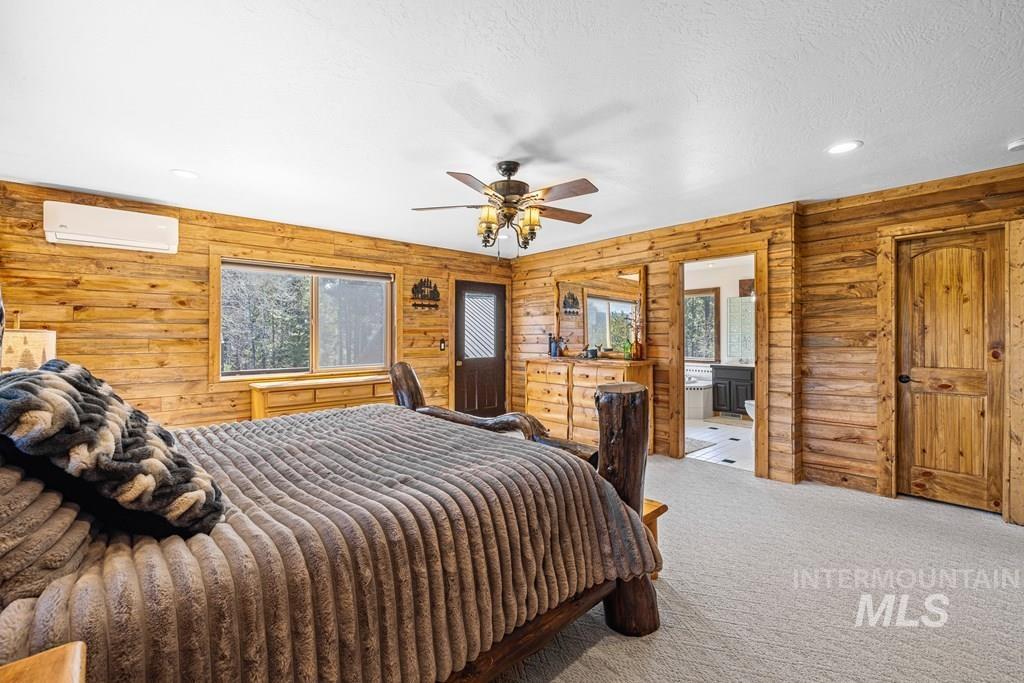 30 Redtail Lane McCall, ID 83638 - Photo 28 of 50 Bedroom featuring carpet flooring, recessed lighting, wood walls, a ceiling fan, and a textured ceiling