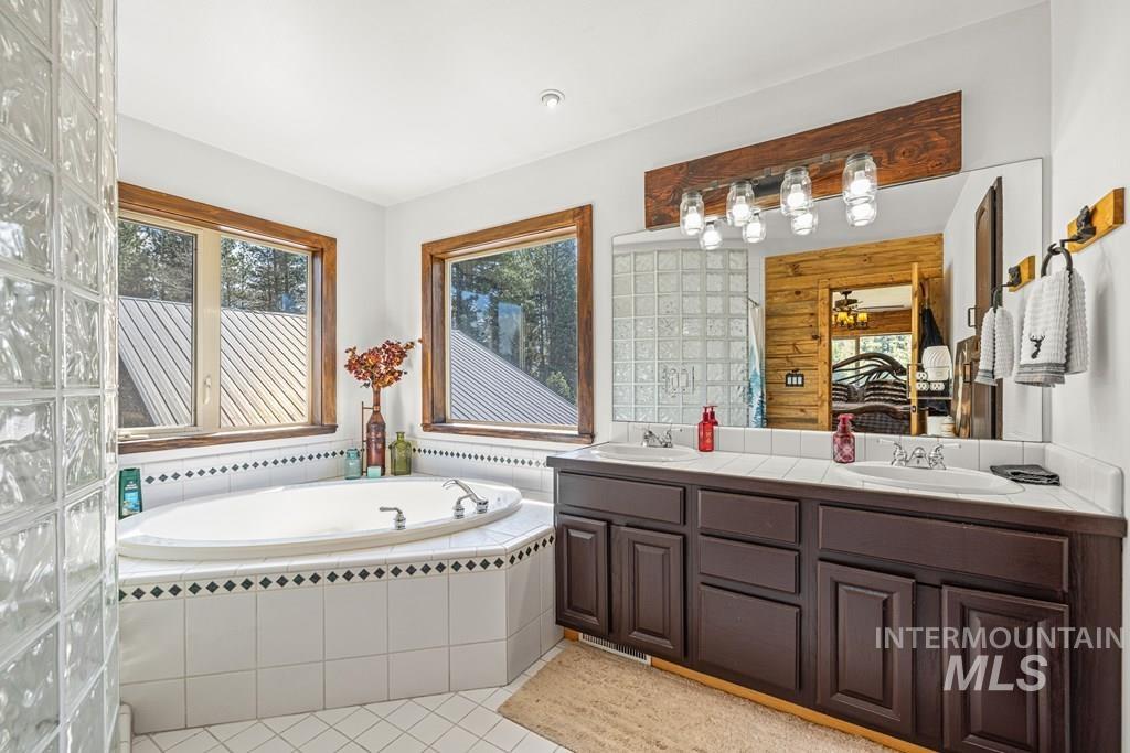 30 Redtail Lane McCall, ID 83638 - Photo 35 of 50 Full bath with a garden tub, double vanity, light tile patterned floors, and ensuite bathroom