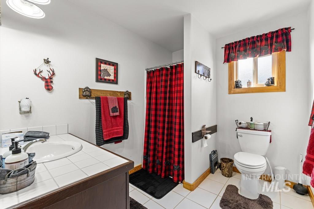30 Redtail Lane McCall, ID 83638 - Photo 38 of 50 Full bathroom with a shower with curtain, vanity, and light tile patterned flooring