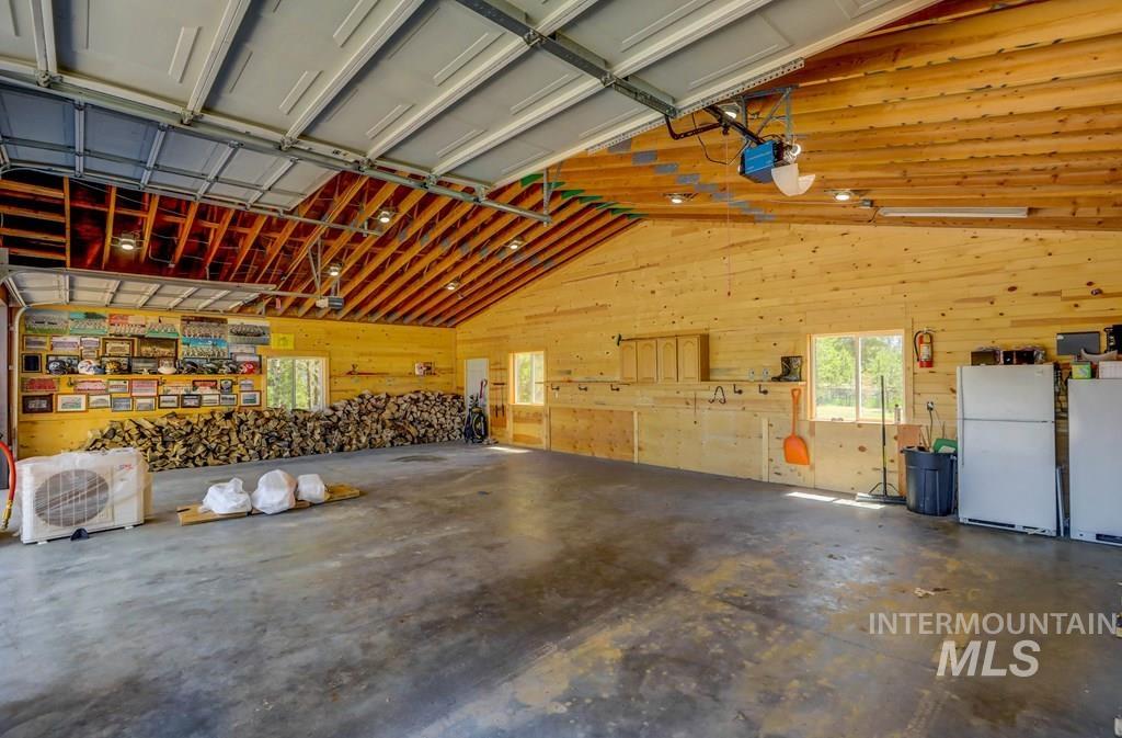 30 Redtail Lane McCall, ID 83638 - Photo 43 of 50 Garage with freestanding refrigerator, wood walls, and a garage door opener