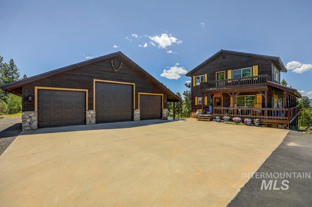 30 Redtail Lane McCall, ID 83638 - Photo 8 of 50 View of front facade featuring a large porch, an outdoor structure, a garage, and stone siding
