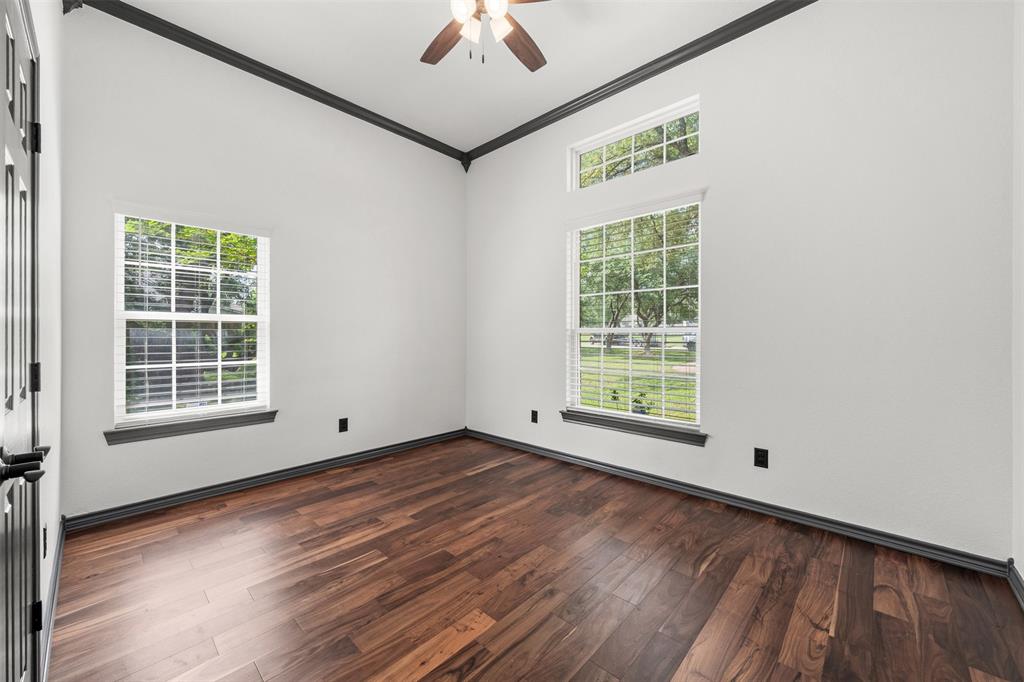 3091 Rockbridge Road McGregor, TX 76657 - Photo 18 of 40 an empty room with wooden floor chandelier fan and windows