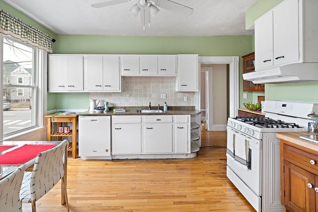 a kitchen with granite countertop a sink a stove and cabinets