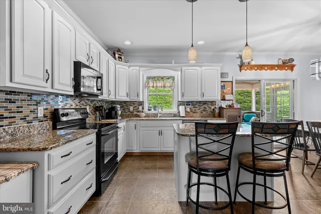 a kitchen with stainless steel appliances granite countertop wooden cabinets a stove a sink and dishwasher