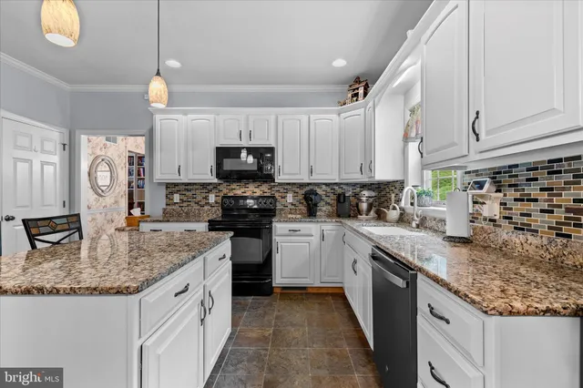 a kitchen with granite countertop a sink a counter top space appliances and cabinets