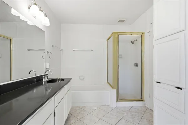 a spacious bathroom with a granite countertop sink a mirror and shower