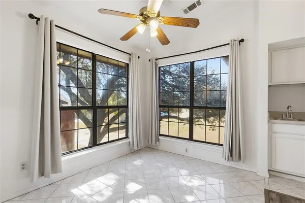 a view of an empty room with a window and a ceiling fan