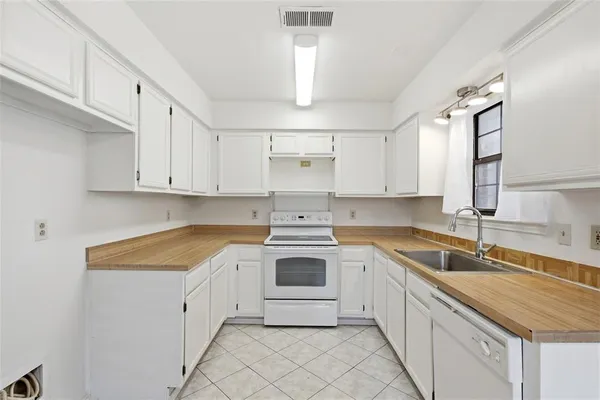 a kitchen with granite countertop white cabinets and white appliances