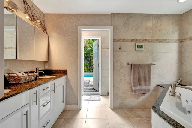 a spacious bathroom with a granite countertop sink a toilet a mirror and shower