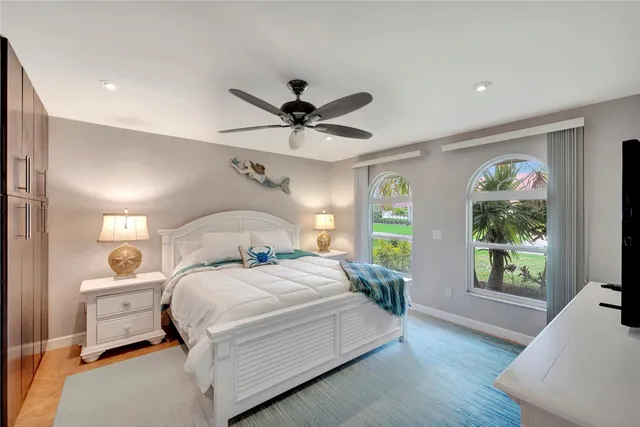 a bedroom with a bed and a large window with the outer view