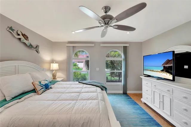 a bedroom with a large bed and a flat tv screen on dresser