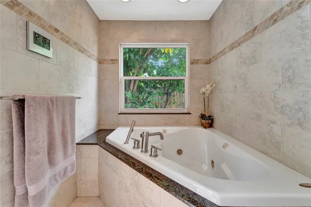 a white bath tub sitting in a bathroom next to a window