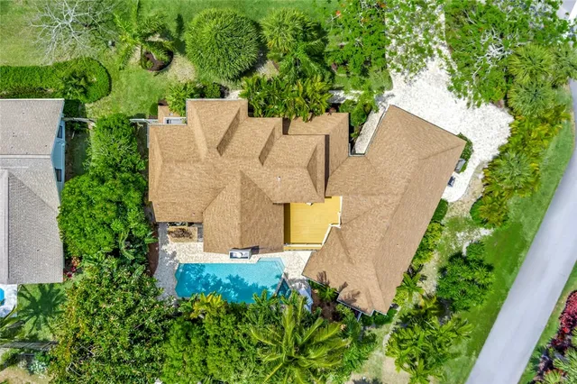 an aerial view of residential house with outdoor space and trees all around
