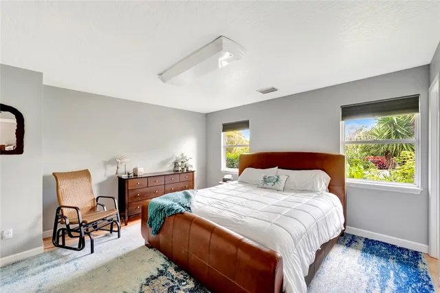 a bedroom with a bed chair and window