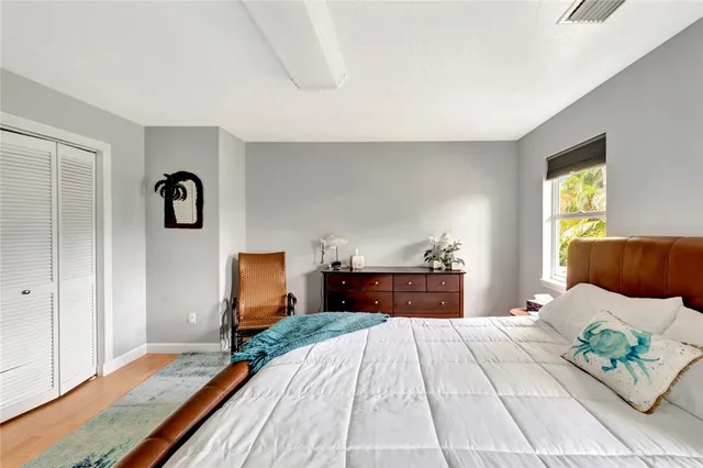 a bedroom with a bed and wooden floor