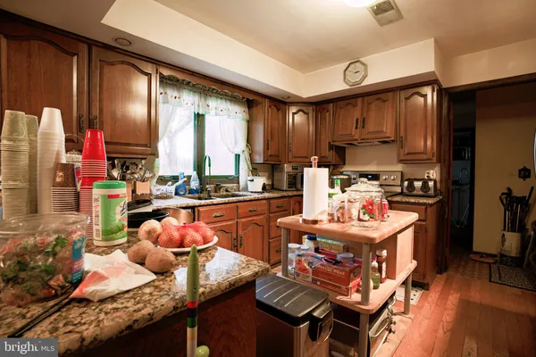 a kitchen with granite countertop lots of clutter and stainless steel appliances