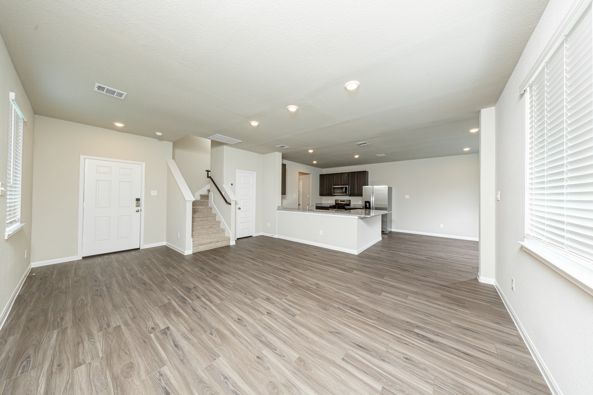 13663 Kit Run Splendora, TX 77372 - Photo 3 of 28 a view of empty room with wooden floor and kitchen