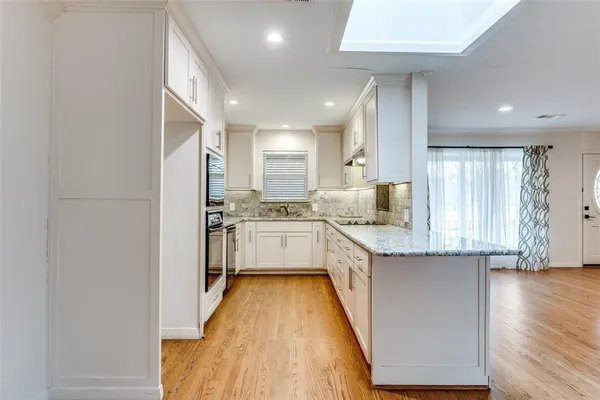 a kitchen with granite countertop white cabinets and white appliances