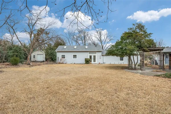 a front view of house with yard and trees around