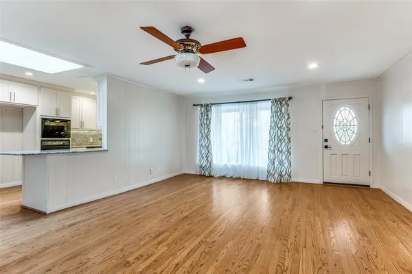 a view of a livingroom with hardwood floor and a ceiling fan