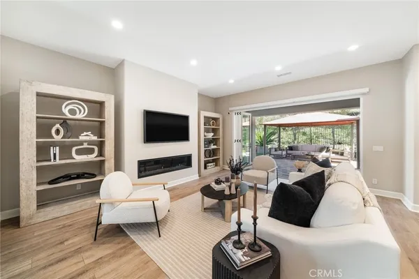 a living room with furniture flat screen tv and a large window