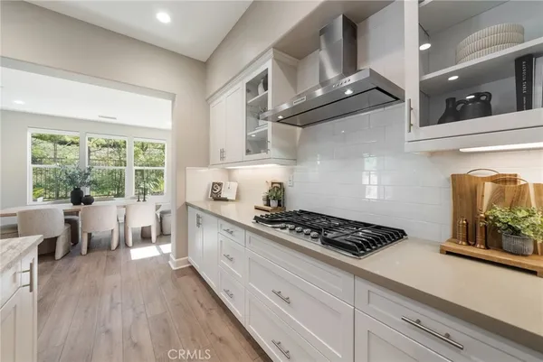 a large kitchen with stainless steel appliances kitchen island granite countertop a large counter top a couch and a view of living room