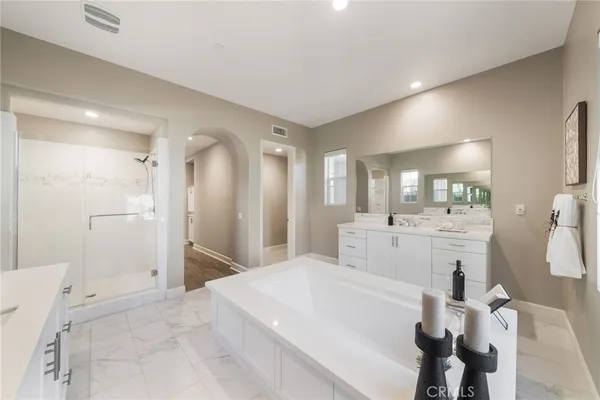 a bathroom with a toilet a sink a mirror a bathtub and vanity