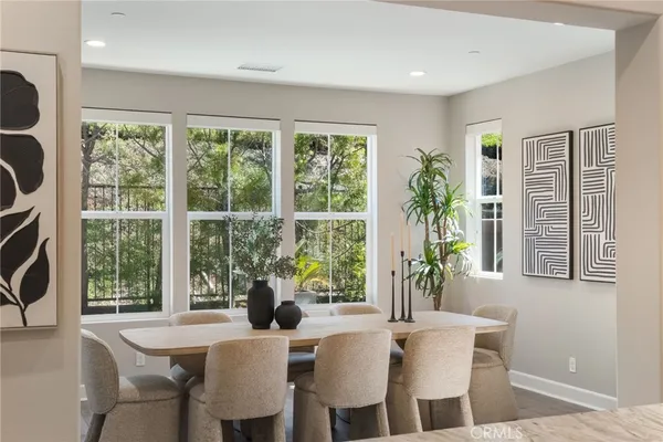 a kitchen with stainless steel appliances granite countertop a stove top oven a refrigerator a sink and a dining table with wooden floor