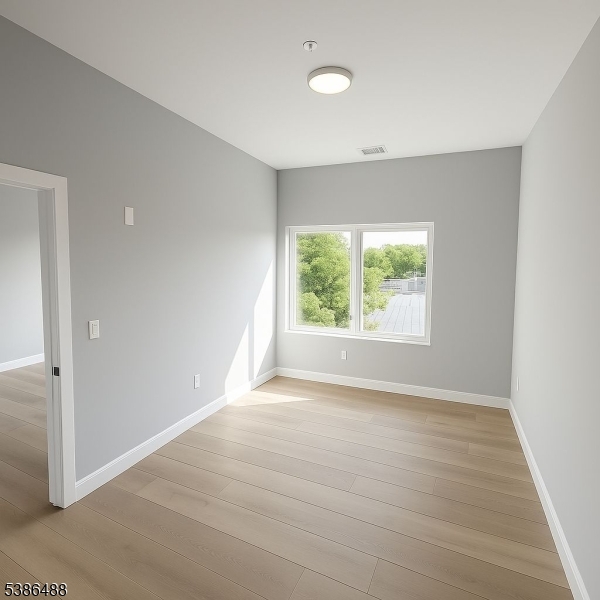 391 Springfield Avenue, Unit 3H Berkeley Heights, NJ 07922 - Photo 2 of 14 an empty room with wooden floor and windows