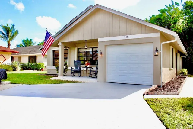 a view of a house with a yard and potted plants
